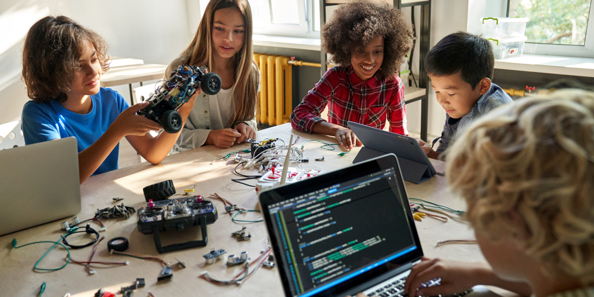A group of children playing with a STEM robot toy.