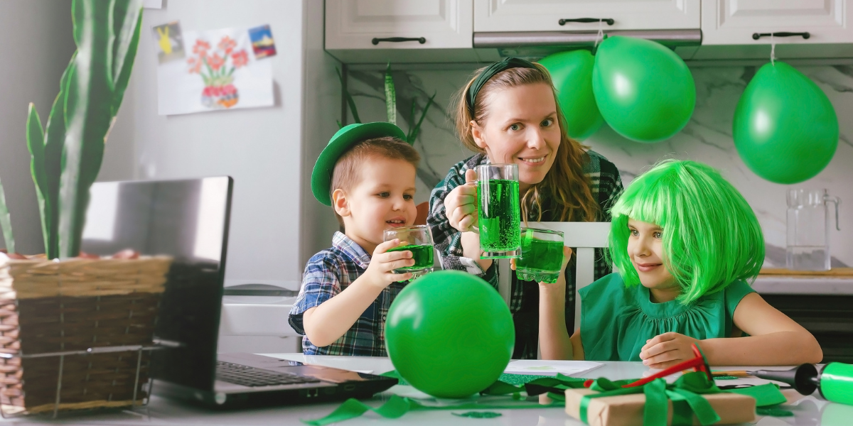 A family with two kids decorating shamrock-shaped cookies and preparing festive treats as part of kid-friendly St. Patrick's Day activities.