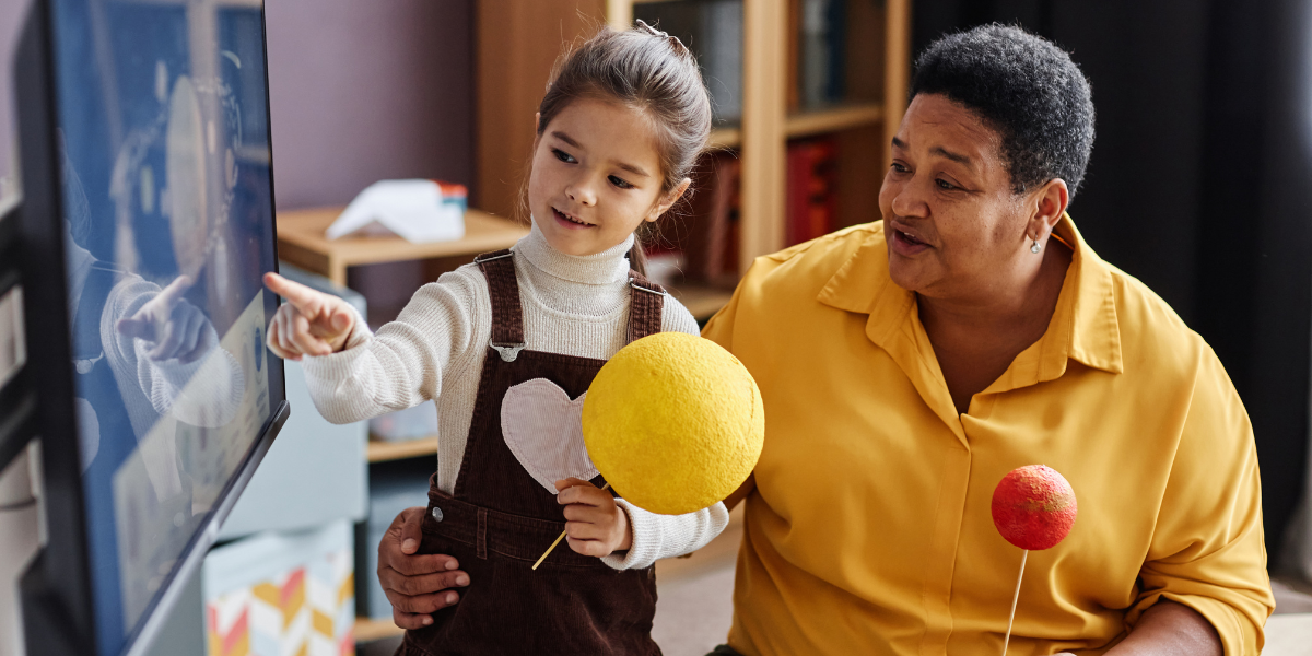 Student and educator exploring a planetary display, using 3D models to enhance understanding of space science concepts in an engaging Engineering For Kids<sup srcset=